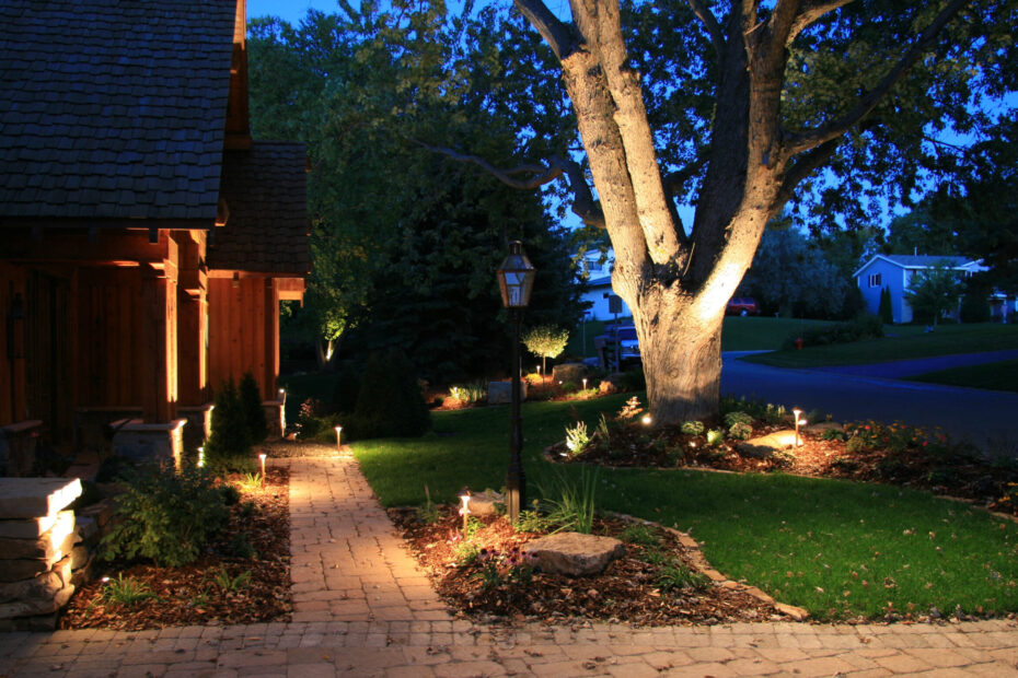 Home Security side view of the front of a house with spotlights and a floodlight on a tree.