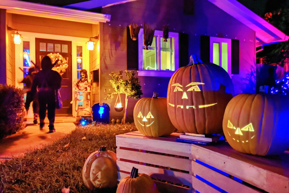 Trick-or-treaters on Halloween with jack-o-lantern decorations